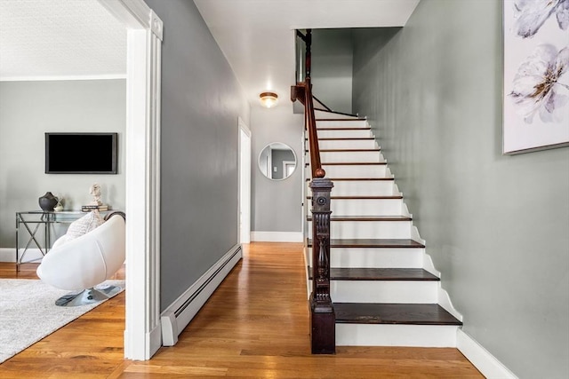 24 Willard St, Malden, MA 02148 - stairs featuring baseboard heating and wood finished floors
