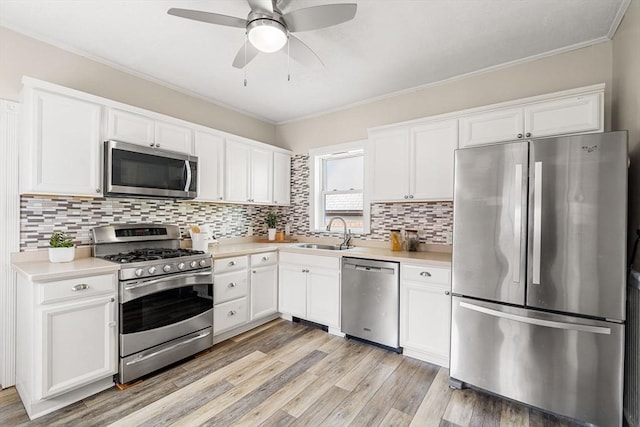 24 Willard St, Malden, MA 02148 - kitchen with stainless steel appliances, light countertops, a ceiling fan, crown molding, and backsplash