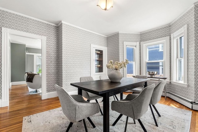 24 Willard St, Malden, MA 02148 - dining room featuring wood-type flooring, ornamental molding, wallpapered walls, and a baseboard radiator