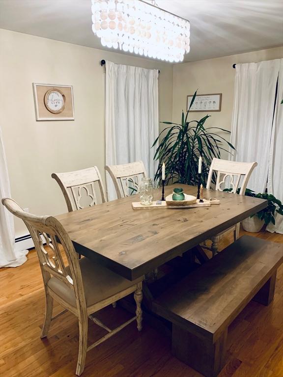 dining space with light wood finished floors and an inviting chandelier