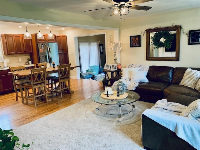 living room featuring light wood-type flooring and ceiling fan