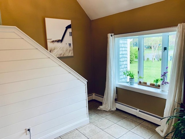 interior space featuring stairway, a baseboard radiator, light tile patterned flooring, and vaulted ceiling