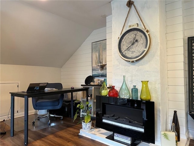 office area featuring wooden walls, vaulted ceiling, and wood finished floors