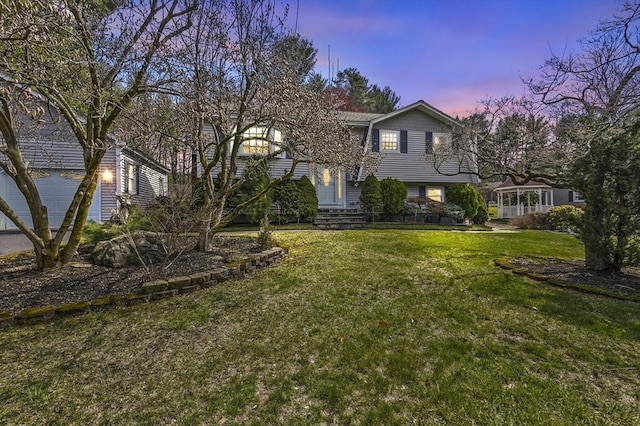 view of front of property featuring a lawn and a garage