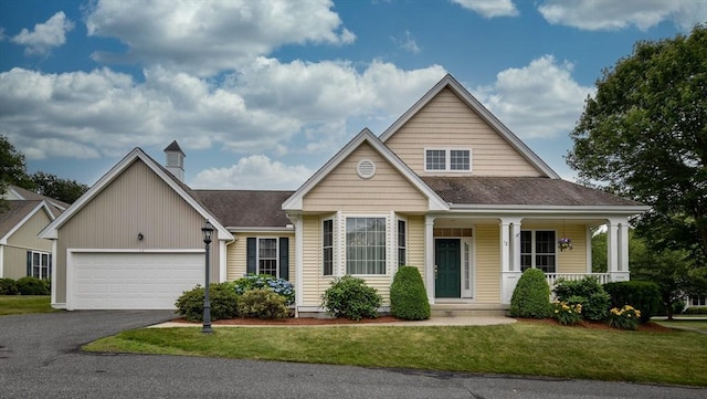 12 Braeburn Ln Unit 12, Ashland, MA 01721 - view of front of home featuring asphalt driveway, a garage, a front yard, covered porch, and roof with shingles