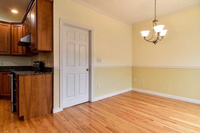 12 Braeburn Ln Unit 12, Ashland, MA 01721 - kitchen featuring stainless steel range with electric stovetop, under cabinet range hood, a chandelier, light wood-style floors, and crown molding
