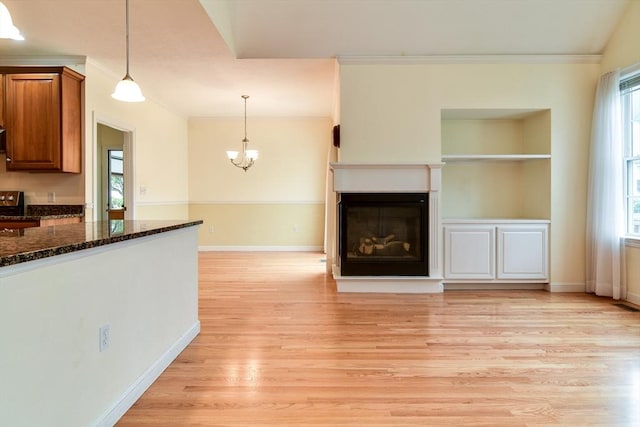 12 Braeburn Ln Unit 12, Ashland, MA 01721 - unfurnished living room featuring ornamental molding, light wood-style floors, a fireplace, and a chandelier