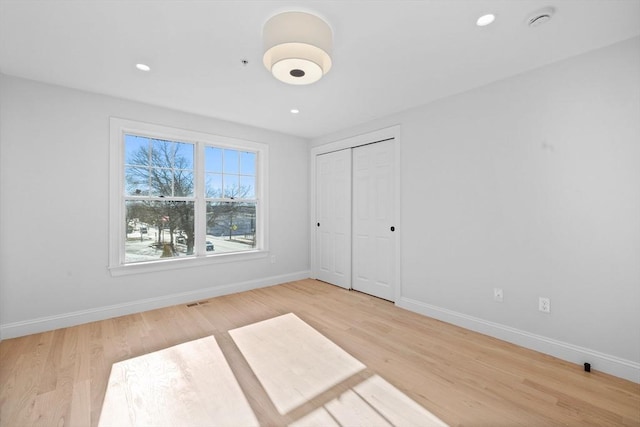 unfurnished bedroom with wood-type flooring and a closet