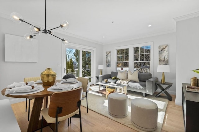 living room with an inviting chandelier, light hardwood / wood-style flooring, and ornamental molding