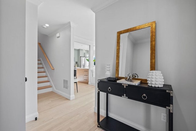 interior space with ornamental molding and light wood-type flooring