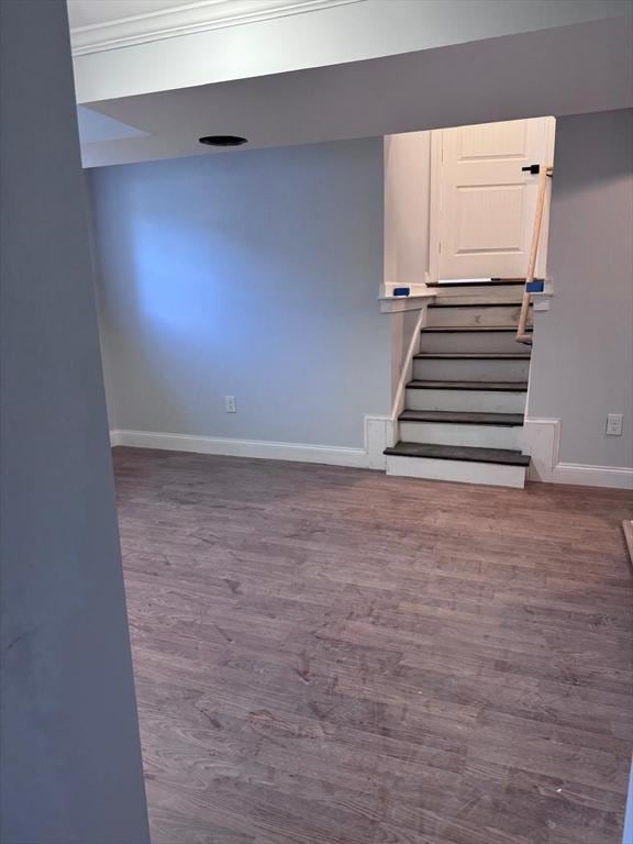 basement with hardwood / wood-style flooring and crown molding