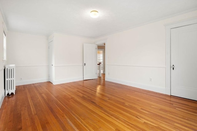 8 Warren Rd, Marblehead, MA 01945 - empty room featuring radiator heating unit, hardwood / wood-style flooring, ornamental molding, and baseboards