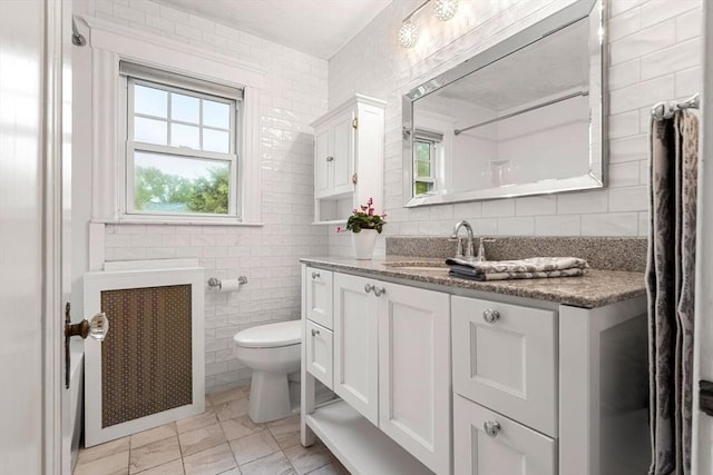 8 Warren Rd, Marblehead, MA 01945 - full bathroom with radiator, tile walls, vanity, toilet, and tasteful backsplash