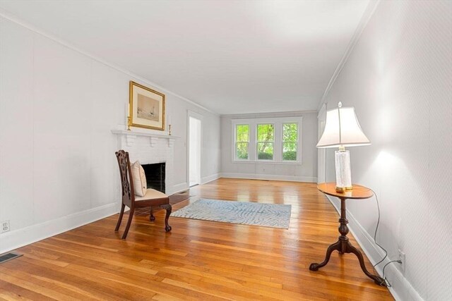 8 Warren Rd, Marblehead, MA 01945 - living area with ornamental molding, light wood-type flooring, a brick fireplace, and baseboards