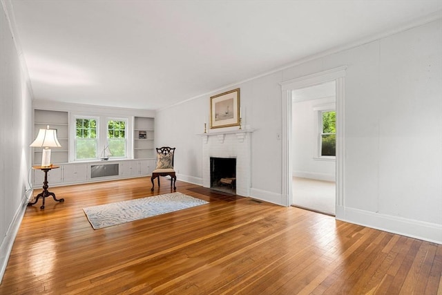 8 Warren Rd, Marblehead, MA 01945 - living room with built in features, a fireplace, hardwood / wood-style floors, and baseboards