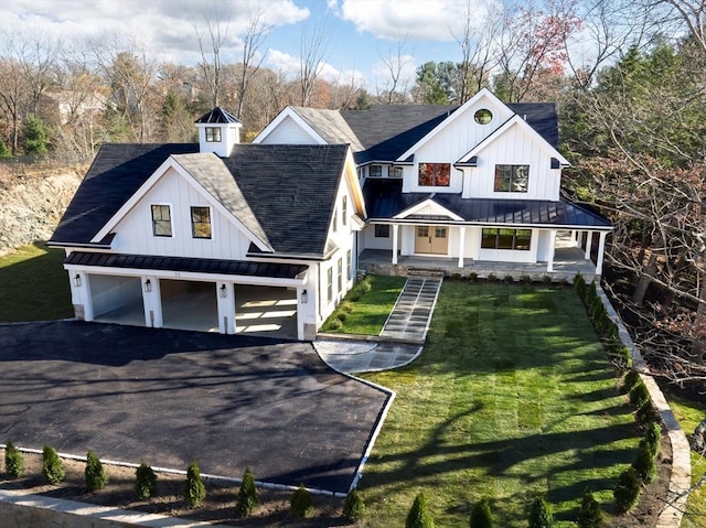 view of front of property with covered porch, a front yard, and a garage