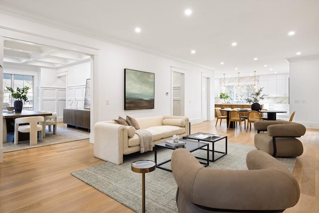 living room featuring beamed ceiling, light hardwood / wood-style floors, ornamental molding, and coffered ceiling