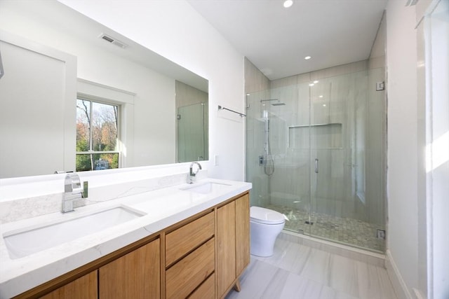 bathroom featuring vanity, toilet, and a shower with door