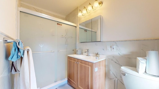 bathroom with vanity, toilet, a shower with door, and tile walls