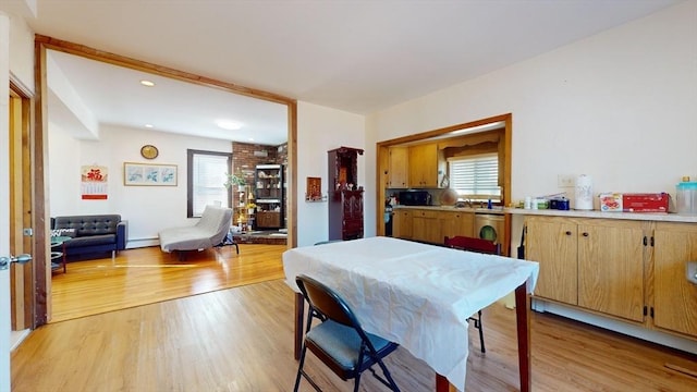 dining area with a baseboard radiator and light hardwood / wood-style flooring