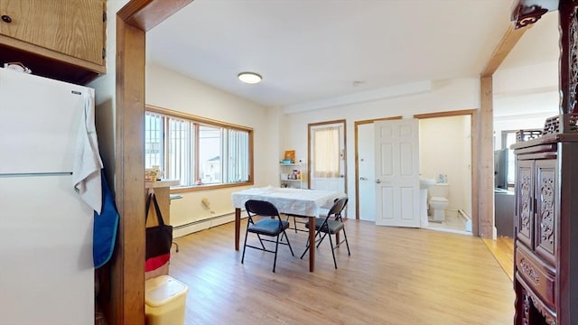 dining area with light hardwood / wood-style flooring and baseboard heating