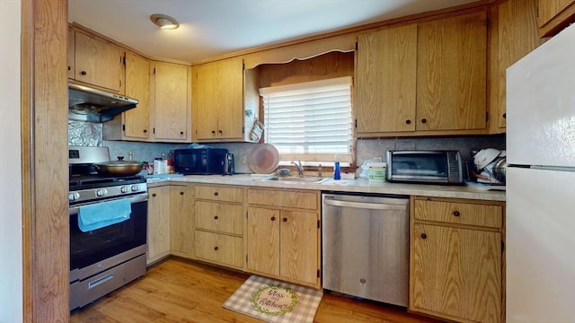 kitchen featuring decorative backsplash, stainless steel appliances, light hardwood / wood-style flooring, and sink