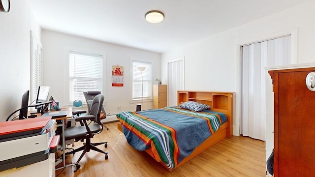 bedroom with light hardwood / wood-style flooring and a baseboard radiator