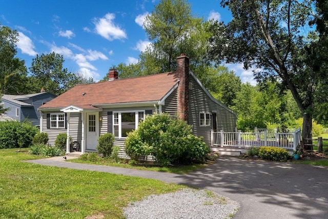 328 N Main St, Sharon, MA 02067 - view of front of home featuring a deck, a chimney, a front lawn, and asphalt driveway