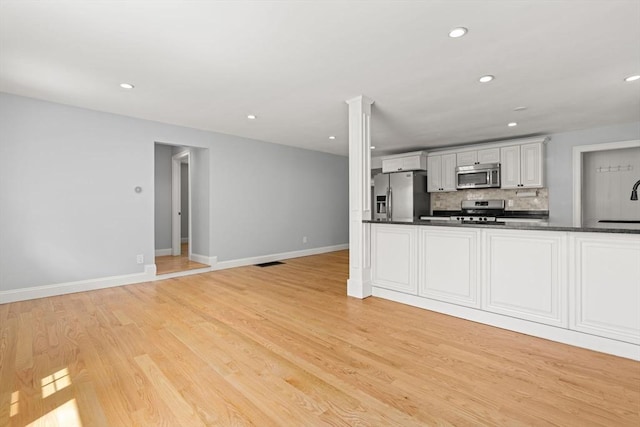 328 N Main St, Sharon, MA 02067 - kitchen with appliances with stainless steel finishes, recessed lighting, tasteful backsplash, dark countertops, and light wood-style floors