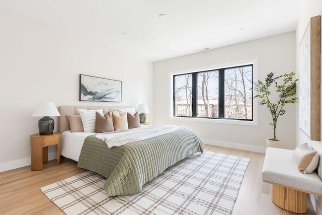 bedroom with light wood finished floors and baseboards