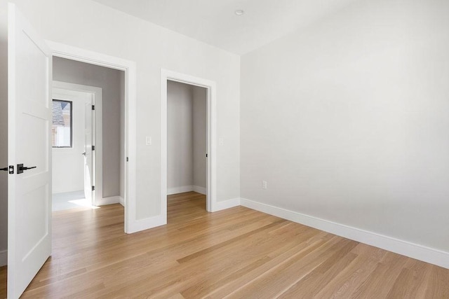 unfurnished bedroom featuring light wood-type flooring and baseboards