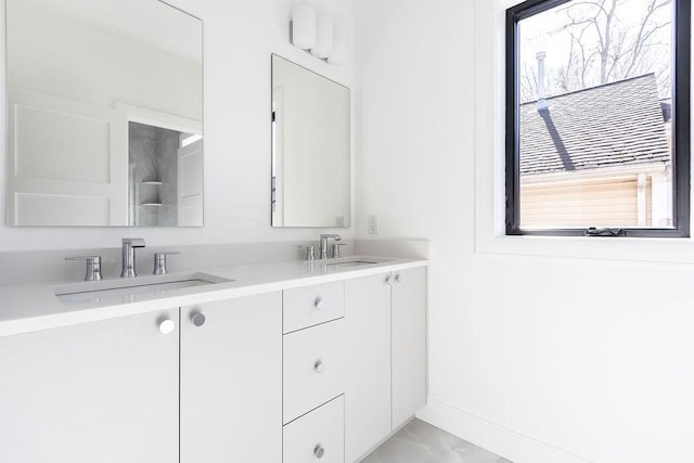 full bath with a sink, baseboards, and double vanity