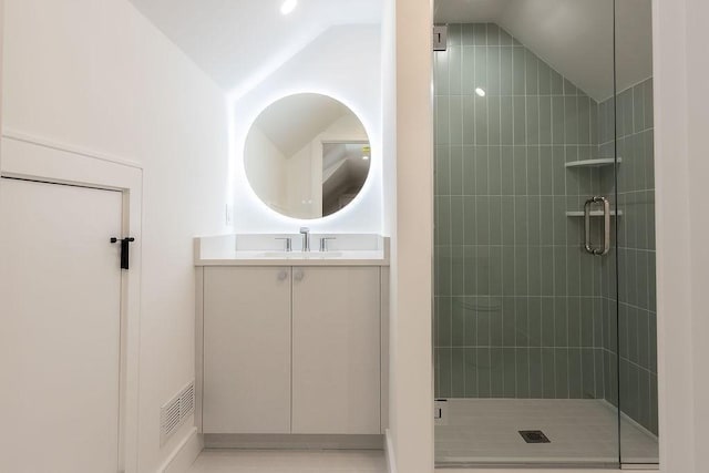 bathroom featuring vanity, vaulted ceiling, visible vents, and a stall shower