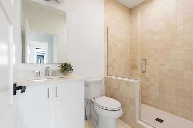 full bathroom featuring vanity, a shower stall, and toilet