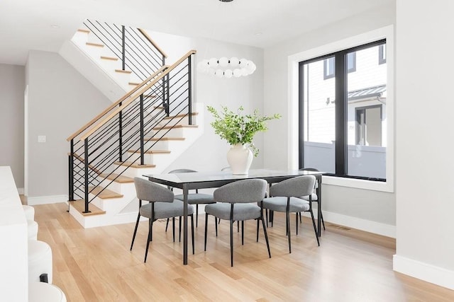 dining space with visible vents, stairway, wood finished floors, and baseboards