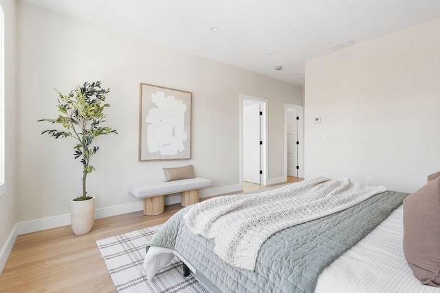 bedroom with baseboards and light wood finished floors