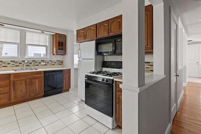 17-19 Maple St, Newton, MA 02466 - kitchen with black appliances, a sink, backsplash, and light countertops