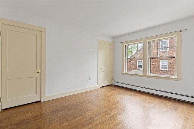17-19 Maple St, Newton, MA 02466 - spare room with wood finished floors, a baseboard radiator, and baseboards