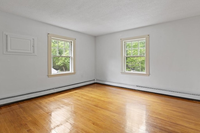 17-19 Maple St, Newton, MA 02466 - unfurnished room featuring plenty of natural light, hardwood / wood-style flooring, a textured ceiling, and a baseboard heating unit