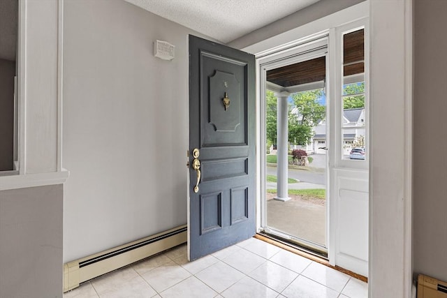 17-19 Maple St, Newton, MA 02466 - foyer entrance with baseboard heating, light tile patterned flooring, a textured ceiling, and a baseboard radiator