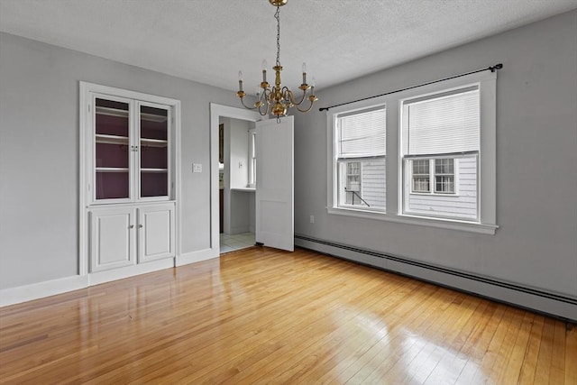 17-19 Maple St, Newton, MA 02466 - unfurnished room featuring a baseboard radiator, a chandelier, wood-type flooring, and a textured ceiling