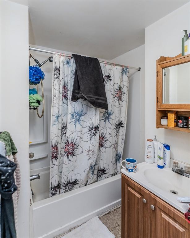 bathroom featuring tile patterned floors, vanity, and shower / bathtub combination with curtain