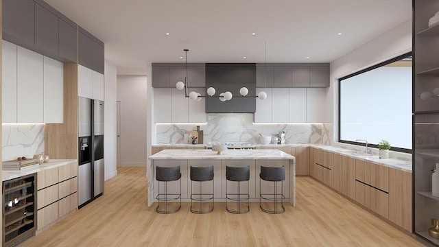 51 Willard Rd, Weston, MA 02493 - kitchen featuring modern cabinets, beverage cooler, a kitchen bar, tasteful backsplash, and a center island