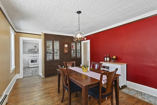 dining area with dark hardwood / wood-style flooring, crown molding, a baseboard radiator, and a chandelier