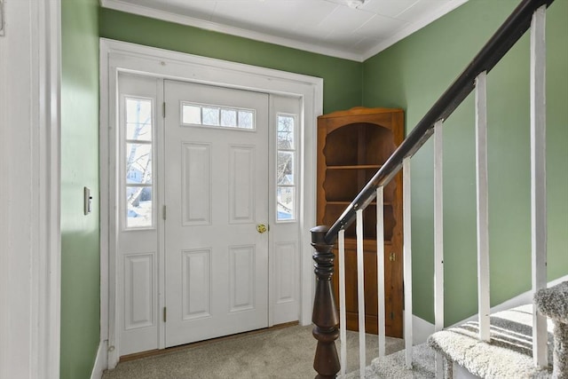 carpeted entrance foyer featuring crown molding