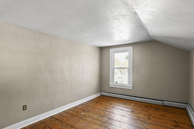 additional living space featuring a baseboard radiator, wood-type flooring, a textured ceiling, and lofted ceiling