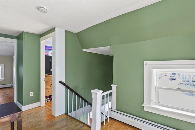 stairs with baseboard heating, hardwood / wood-style floors, and a wealth of natural light