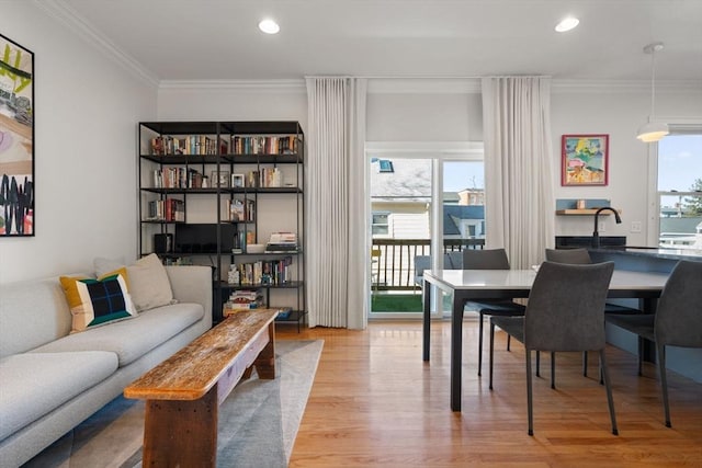 dining room with crown molding and light hardwood / wood-style floors