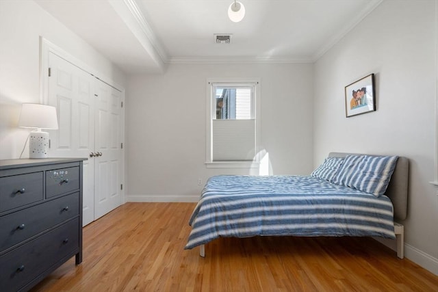 bedroom featuring ornamental molding and light hardwood / wood-style floors