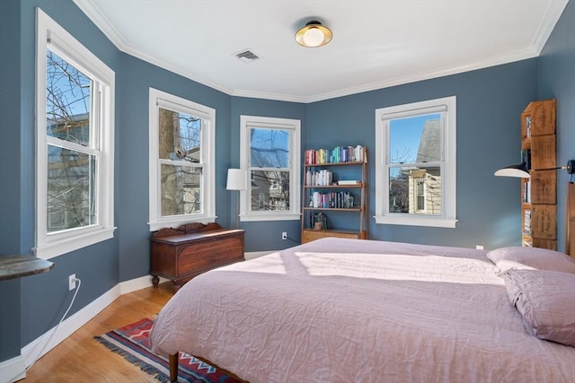 bedroom featuring crown molding and light wood-type flooring